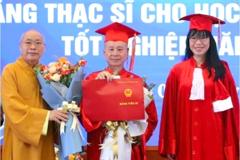 Ông Vương Tấn Việt (Thượng tọa Thích Chân Quang - ở giữa) nhận bằng tiến sĩ của Trường Đại học Luật Hà Nội. Ảnh: Kinh Tế & Đô Thị