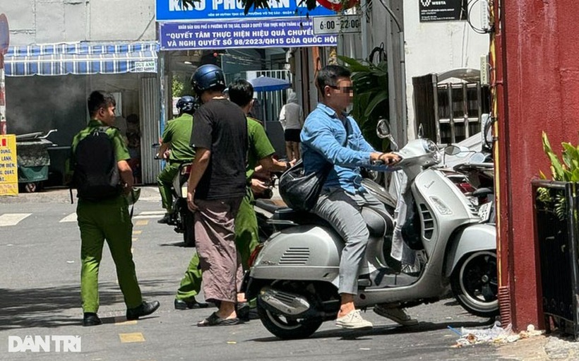 Lực lượng chức năng đưa H. (áo đen) đến hiện trường. Ảnh: Dân Trí