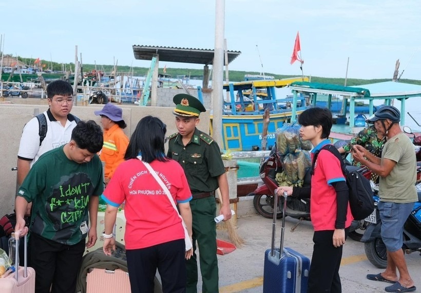 Chiến sĩ Hoa Phượng Đỏ và cán bộ Đồn Biên phòng Thạnh An hỗ trợ thí sinh lên đò. Ảnh: Giáo dục & Thời đại