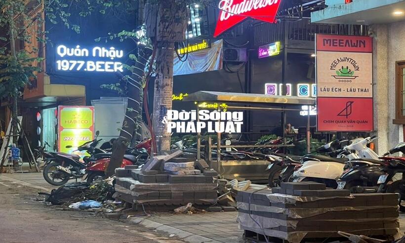 Trước cửa quán nhâu 1977 tại Phố Nguyễn văn Tuyết ngồn ngang vật liệu xây dựng, xe máy đỗ tràn lan.