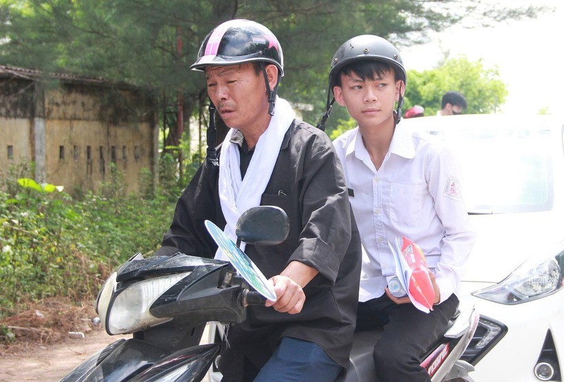Nghẹn lòng hình ảnh người cha choàng khăn tang trắng đưa con đi thi tốt nghiệp. Ảnh: VietNamnet