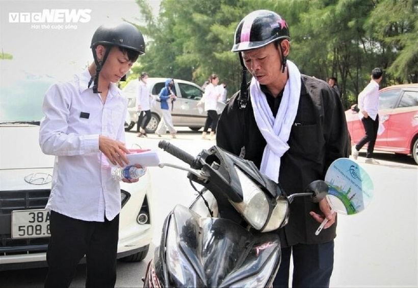 Ông Dũng đeo khăn tang chở con trai tới điểm thi sáng 27/6. Ảnh: VTC News