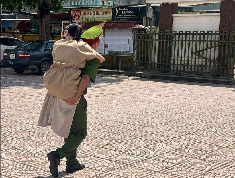 Cán bộ Công an huyện Thanh Thủy cõng thí sinh bị khuyết tật vận động vào phòng thi. Ảnh: VietNamnet