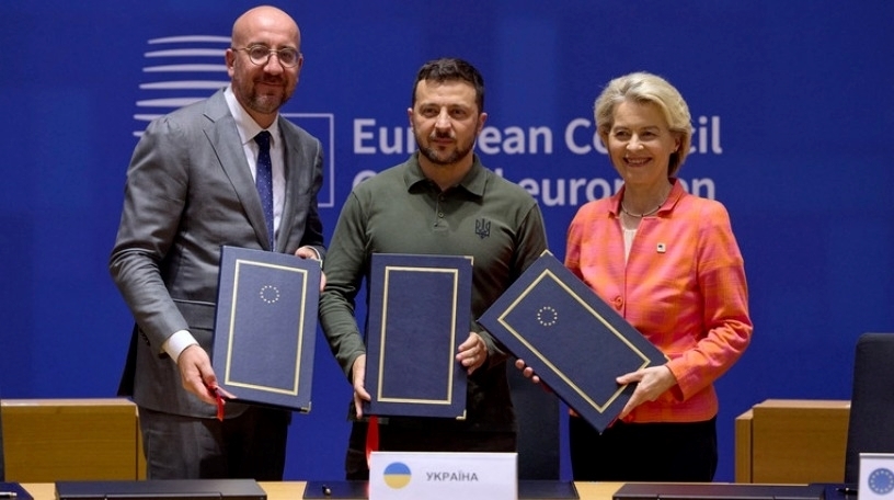 Tổng thống Ukraine Volodymyr Zelensky kỳ thỏa thuận an ninh với Chủ tịch Ủy ban Châu Âu Ursula von der Leyen (phải) và Chủ tịch Hội đồng Châu Âu Charles Michel (trái) tại trụ sở EU ở Brussels, Bỉ, ngày 27/6. Ảnh: RT