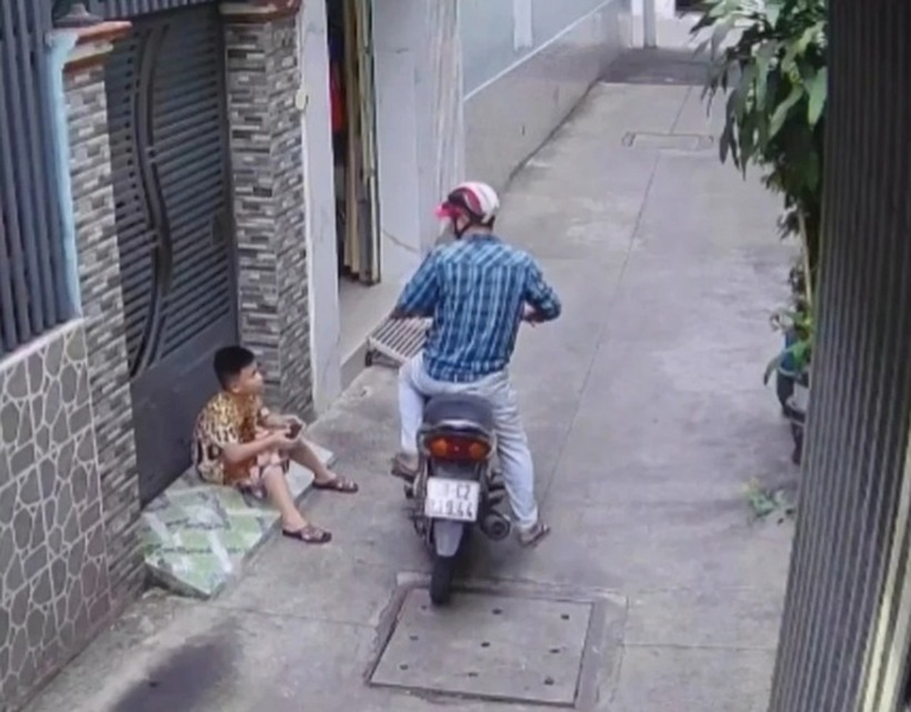 Người đàn ông tiếp cận, giật điện thoại trên tay bé trai rồi bỏ chạy. Ảnh: Thanh Niên