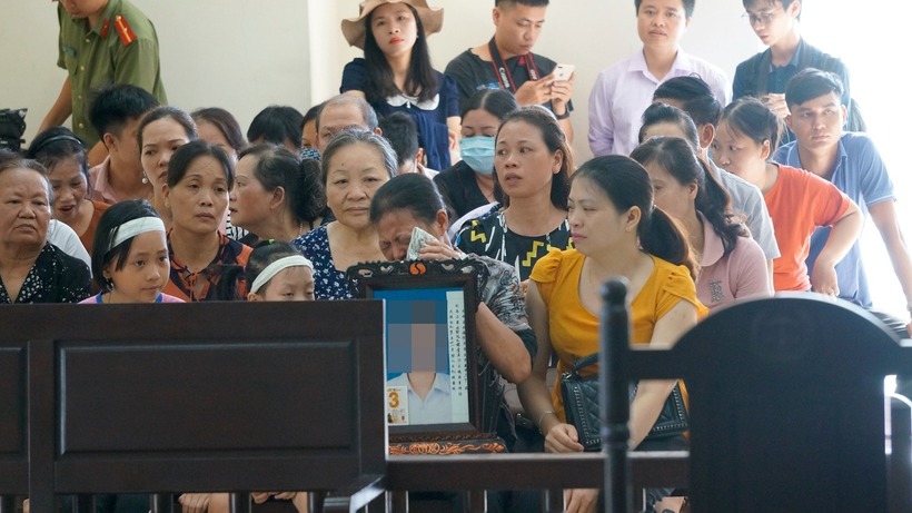 Gia đình nạn nhân mang di ảnh đến dự phiên tòa xét xử Lại Thị Kiều Trang. Ảnh: Thanh Niên