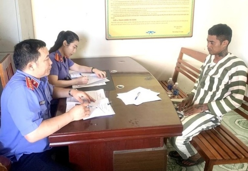 Cán bộ kiểm sát lấy lời khai phạm nhân Trần Duy Đông. Ảnh: Tiền Phong