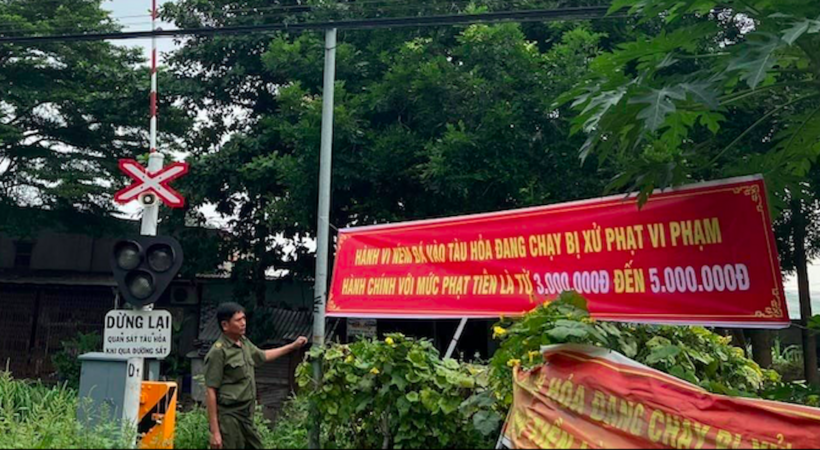 Lực lượng chức năng treo băng rôn tuyên truyền nghiêm cấm hành vi ném đất, đá lên tàu