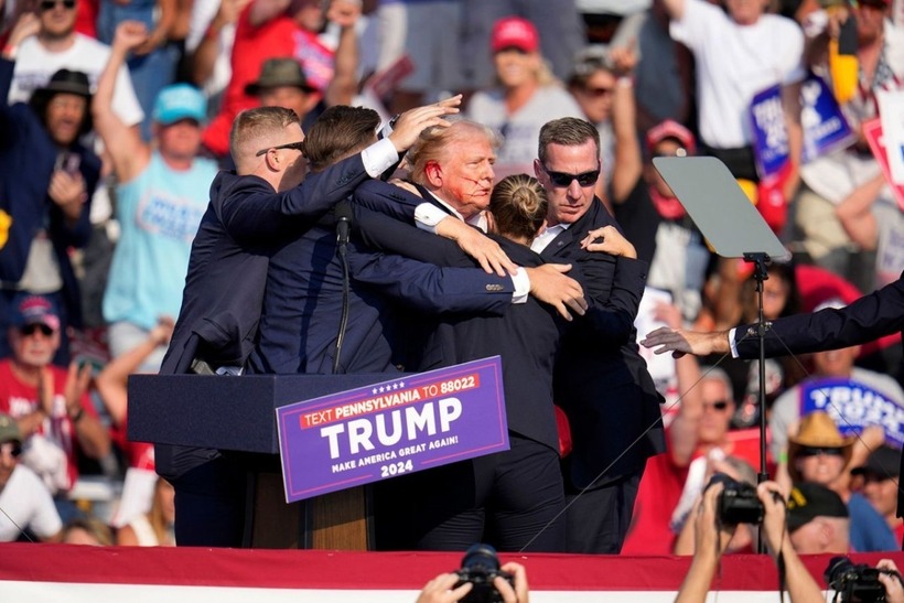 Các đặc vụ hộ tống ông Trump rời khỏi hiện trường. Ảnh: CNN
