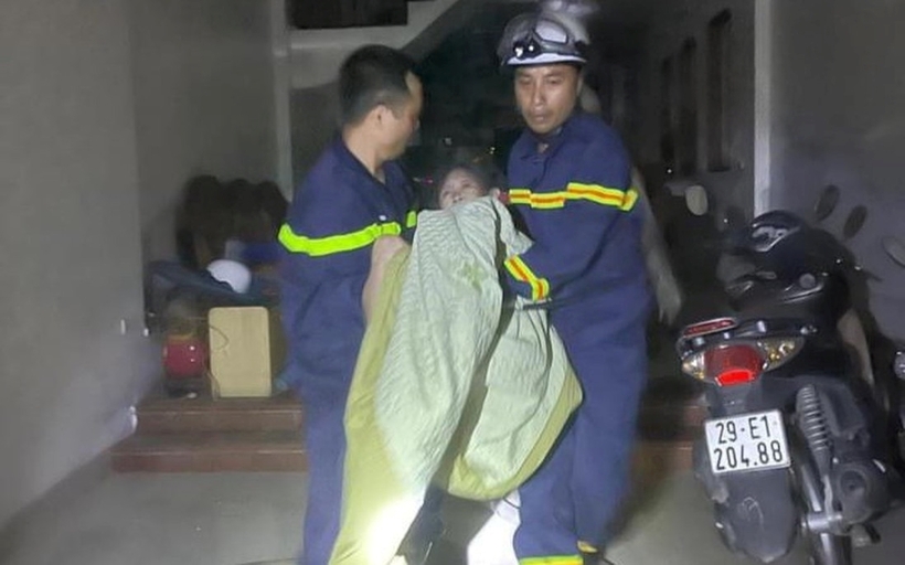 Lực lượng chức năng cứu người đàn ông theo lối thoát tầng thượng nhà hàng xóm. Ảnh: Phụ nữ Việt Nam