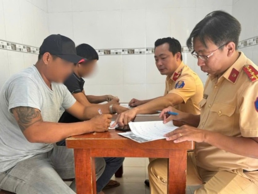 Lực lượng CSGT làm việc với ông N. (áo xám) và chủ xe tải. Ảnh: Báo Tiền Phong