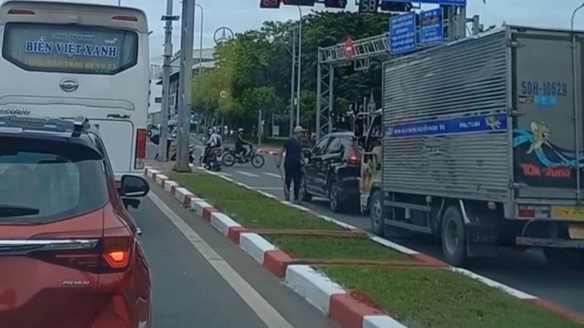 Lái xe N. cầm tuýp sắt nói chuyện với lái xe ô tô 7 chỗ giao lộ Võ Văn Kiệt - Hồ Học Lãm (quận Bình Tân). Ảnh: Báo Nhân Dân