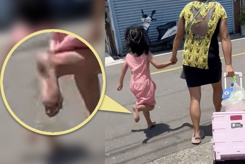 Mặc cho bé gái than nóng nhưng người mẹ vẫn thờ ơ, nắm tay con gái và buộc cô bé phải tiếp tục bước đi. Ảnh: SCMP