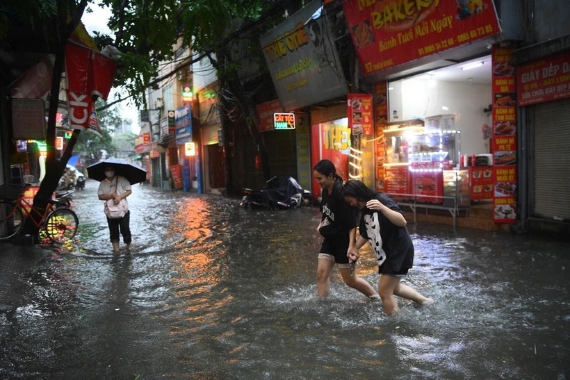 Tuyến đường Triều Khúc, quận Thanh Xuân cũng ngập sâu do mưa lớn. Người đi bộ cũng phải di chuyển khó khăn.