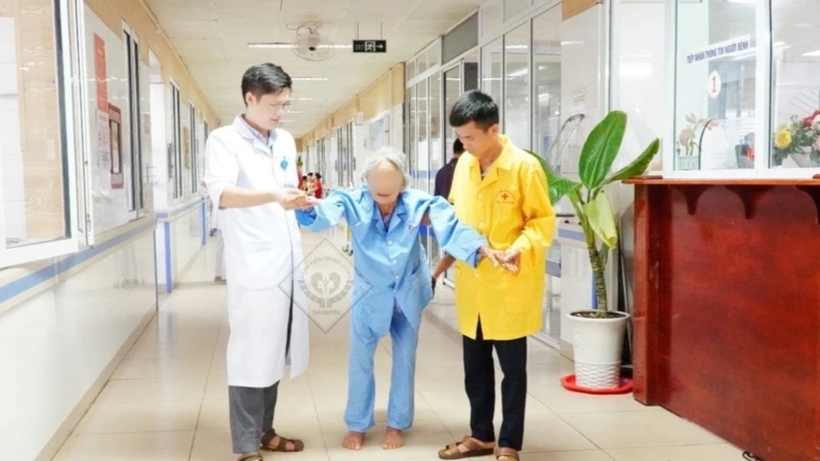 Cụ T. tập đi sau hơn 10 ngày được phẫu thuật, điều trị tích cực. Ảnh: Nhân Dân