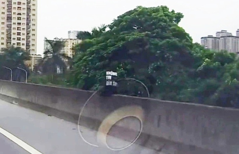 Hình ảnh cô gái ngồi vắt vẻo ở đường vành đai 3 trên cao. Ảnh: Tuổi Trẻ