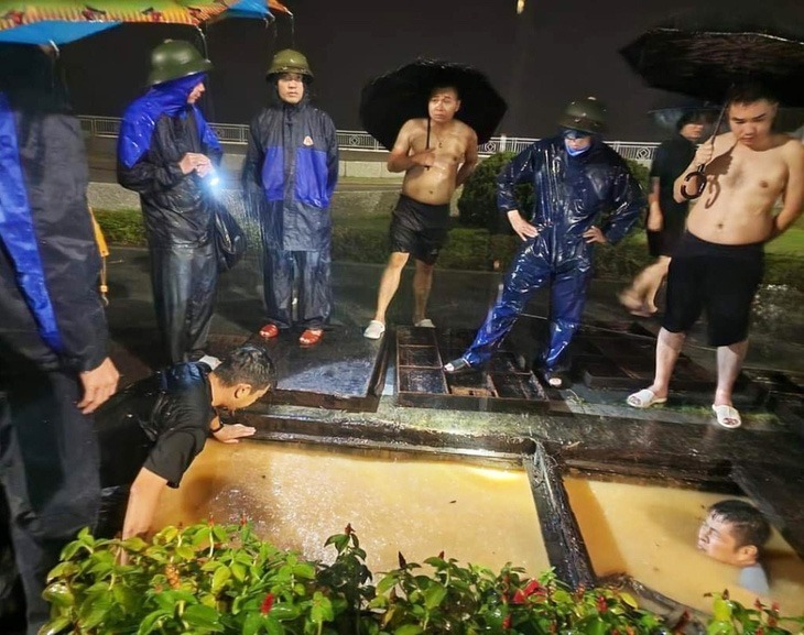 Các cán bộ của TP Hạ Long tổ chức ứng trực xuyên đêm để khơi thông dòng chảy, giảm thiểu tình trạng ngập úng. Ảnh: Tuổi Trẻ