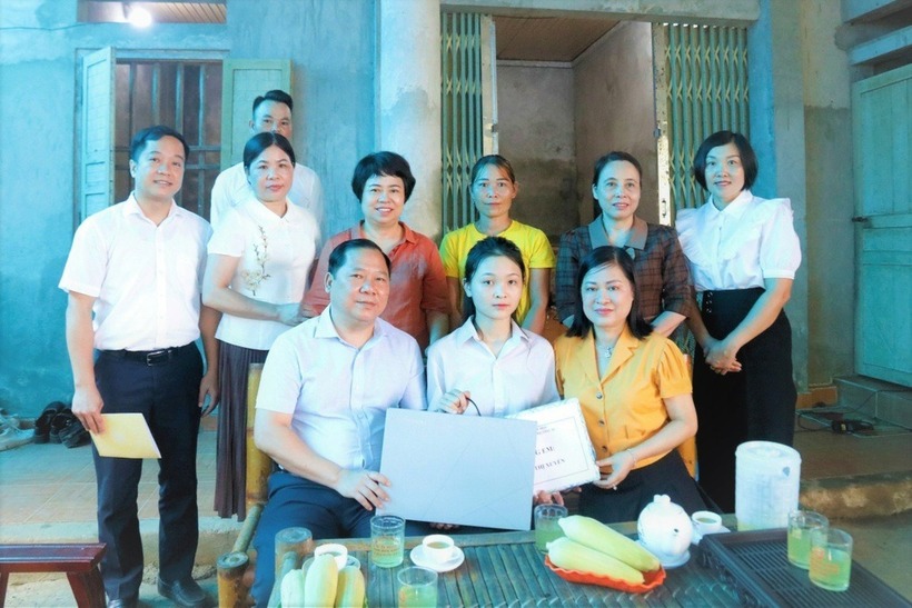 Ông Nguyễn Phi Long, Bí thư Tỉnh ủy Hòa Bình (hàng đầu bên trái) tặng em Đinh Thị Xuyến chiếc máy tính xách tay để học tập tốt hơn ở đại học. (Ảnh: Công lý)