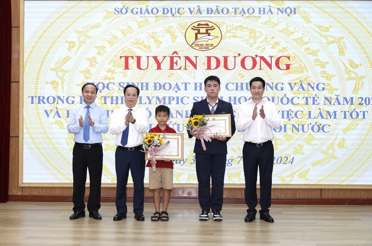 Hai em học sinh có thành tích đặc biệt được TP.Hà Nội, ngành Giáo dục và Đào tạo Hà Nội cùng thầy cô giáo tuyên dương. (Ảnh: Tuổi trẻ)