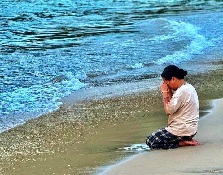 Hình ảnh người mẹ quỳ trên cát tại biển Lăng Cô khiến nhiều người không kìm được nước mắt. Ảnh: VTC News