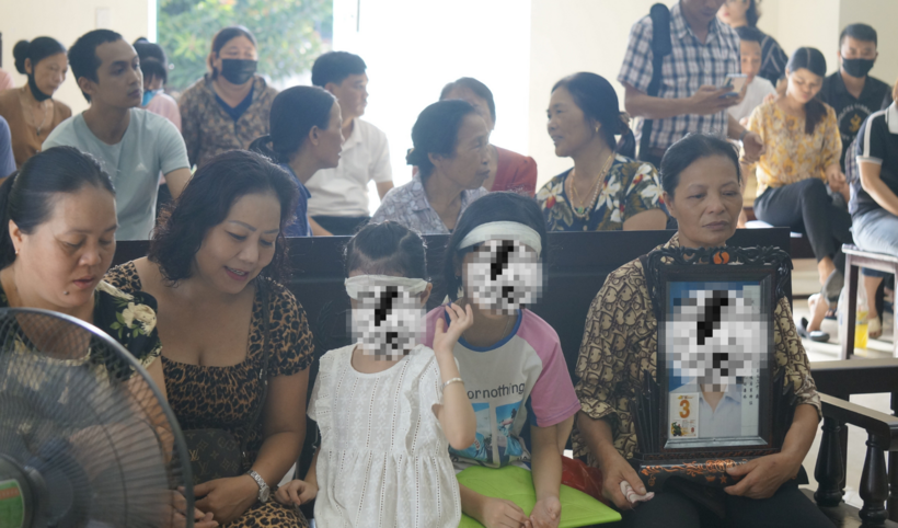 Mẹ (người ôm di ảnh) và các con nạn nhân trong phiên toà xét xử. Ảnh: Thanh Niên
