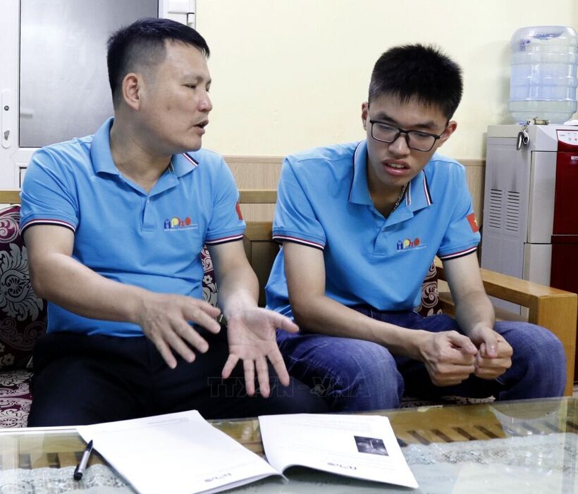 Thân Thế Công cùng thầy giáo Nguyễn Văn Đóa, giáo viên phụ trách tực tiếp trao đổi kiến thức. Ảnh: TTXVN