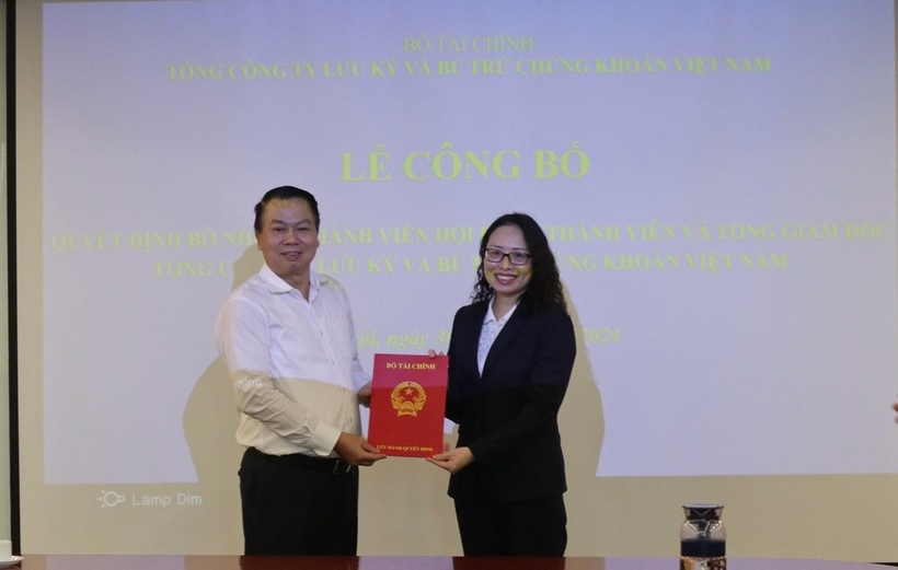 Thứ trưởng Bộ Tài chính Nguyễn Đức Chi trao Quyết định cho bà Tạ Thanh Bình. Ảnh: SSC.