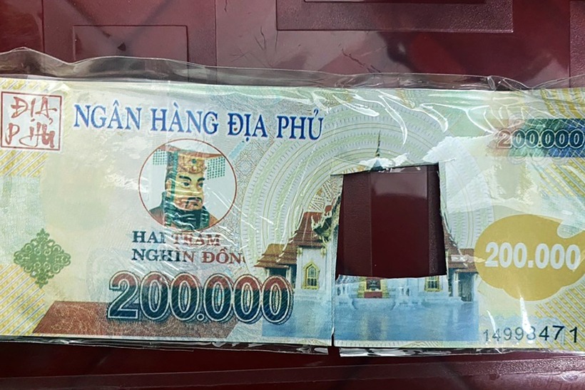 Tiền "âm phủ" được nhóm người sử dụng dán lên bề mặt hộp kiện hàng giao cho khách mua tiền giả. Ảnh: VietNamNet