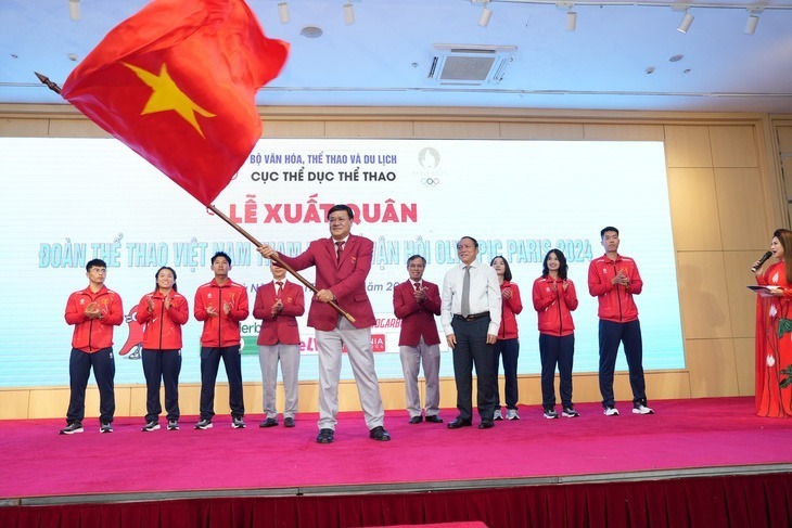 Trưởng đoàn thể thao Việt Nam Đặng Hà Việt phất cờ trong lễ xuất quân. Ảnh: Tuổi Trẻ