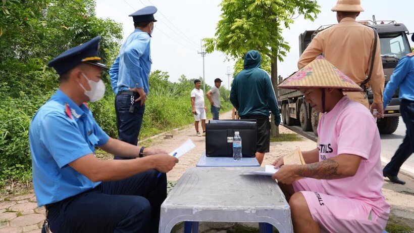 Lực lượng chức năng kiểm tra các xe chở vật liệu xây dựng hoạt động trên đường Ỷ Lan, huyện Gia Lâm, TP.Hà Nội