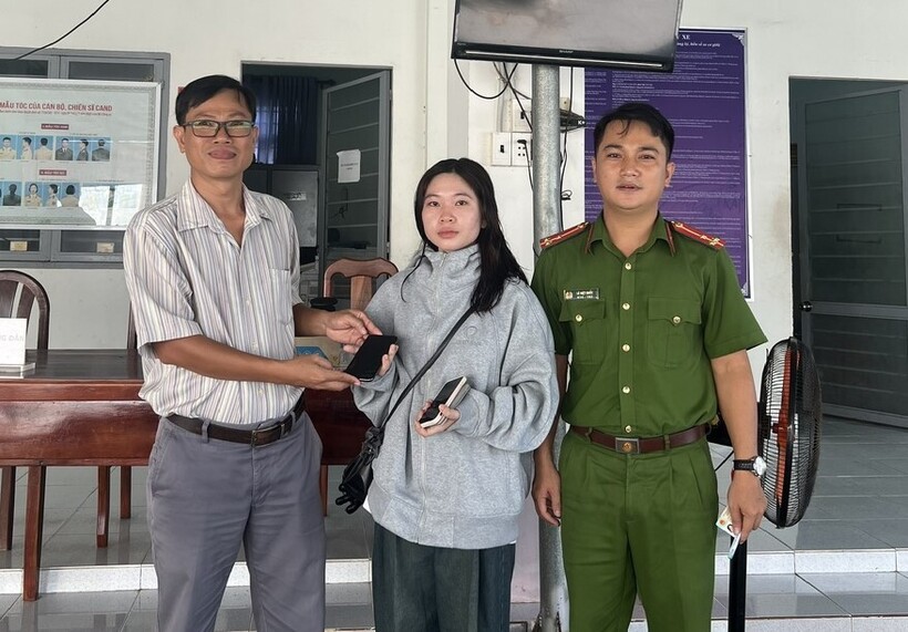 Anh Trần Hoài Phong cùng Công an xã Lợi Thuận bàn giao chiếc điện thoại nhặt được.