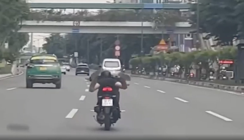 Nam thanh niên nằm trên yên xe chạy tốc độ cao. Ảnh: báo Nhà báo và Công luận.