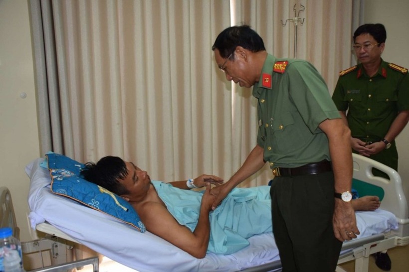 Đại tá Bùi Văn Thảo, Giám đốc Công an tỉnh Bà Rịa-Vũng Tàu thăm hỏi, động viên Thiếu tá Nguyễn Minh Thái tại bệnh viện. Ảnh: Công an nhân dân