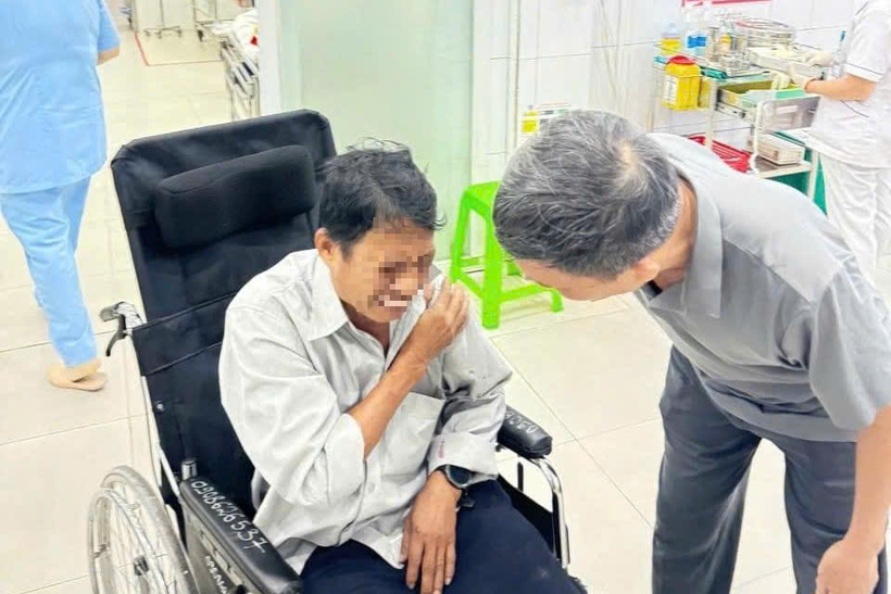 Ông Thi được 3 cảnh sát hỗ trợ đi bệnh viện. (Ảnh: NLĐ)