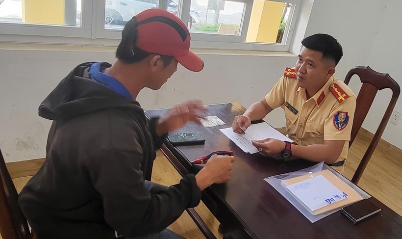 Đại úy Kiều Thanh Hùng làm thủ tục để bàn giao số tiền gần 30 triệu cho anh Phan Ngọc Hùng. (Ảnh: VietnamNet)