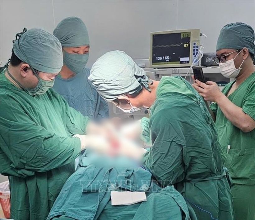 Các bác sĩ phẫu thuật tạo hình cho người bệnh. Ảnh: TTXVN