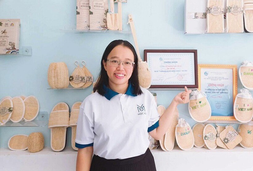 Chị Võ Thị Ngọc Thư bên các sản phẩm khởi nghiệp làm từ xơ mướp thân thiện với môi trường. Mỗi tháng, cơ sở sản xuất của chị Thư cung cấp ra thị trường hàng chục nghìn sản phẩm từ xơ mướp.