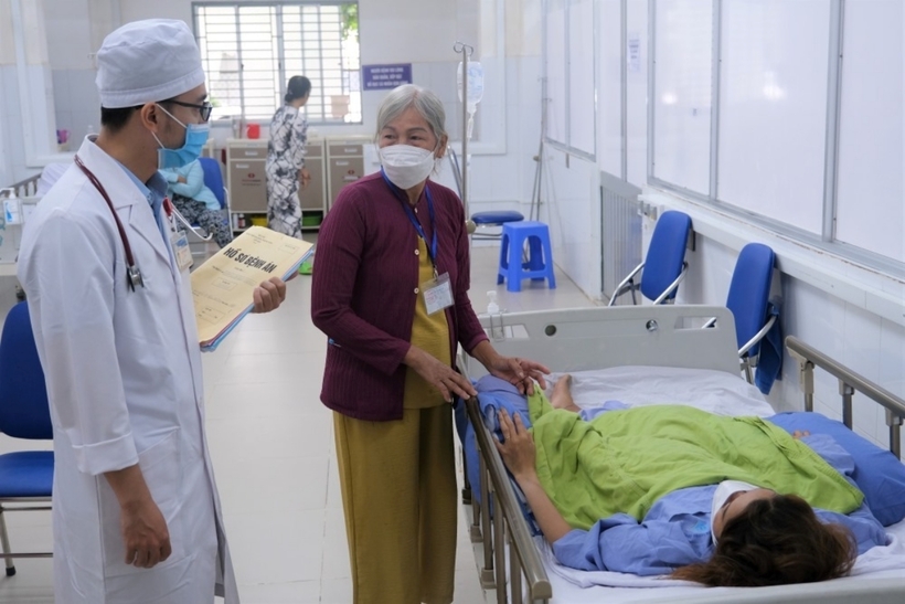 Người mẹ chia sẻ tình hình bệnh của con gái cho bác sĩ. Ảnh: Lao Động