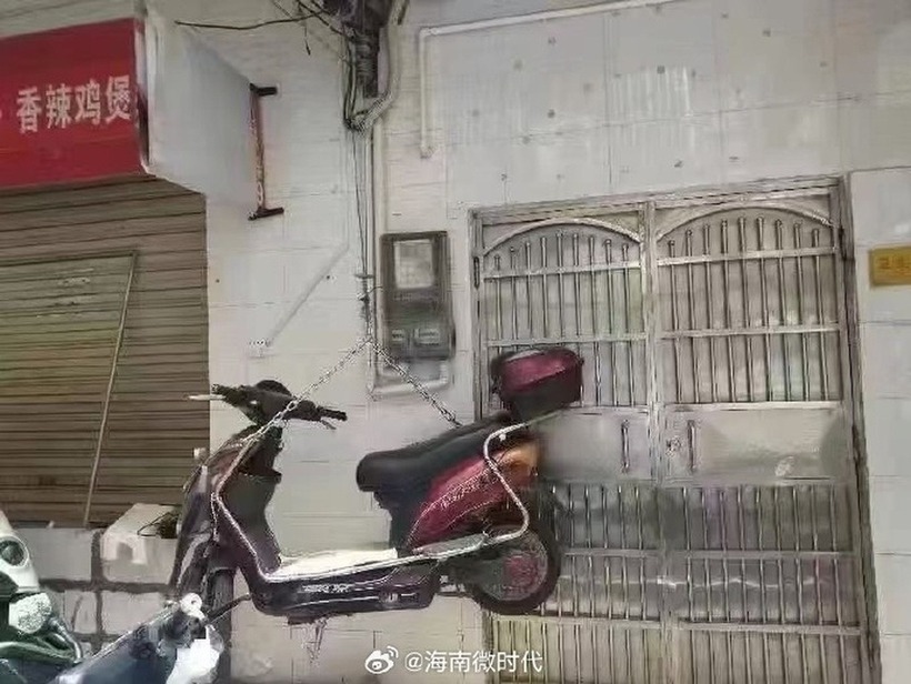 Treo xe máy lên cao để tránh trường hợp ngập lụt do mưa lớn. Ảnh: Weibo.