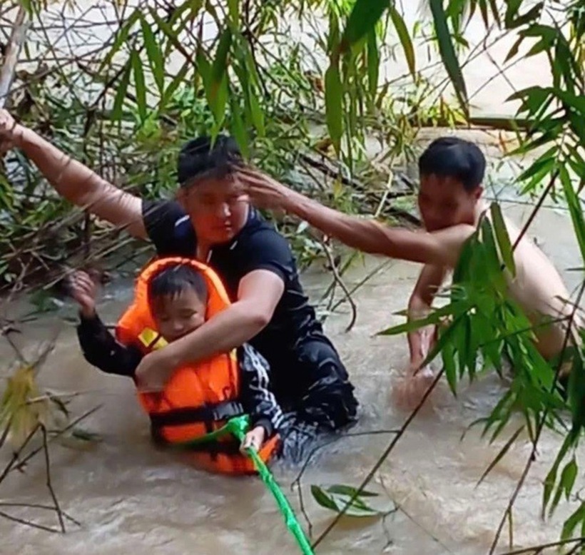 Đại úy Lục Văn Nguyên (áo đen) cùng người dân lao ra dòng lũ để cứu bé Bảo. Ảnh: Thanh Niên