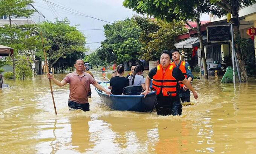 Lực lượng chức năng dùng thuyền đưa trẻ em và phụ nữ đến nơi an toàn