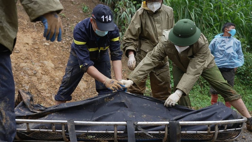 Lực lượng chức năng đưa thi thể nạn nhân ra ngoài. Ảnh: VietNamNet