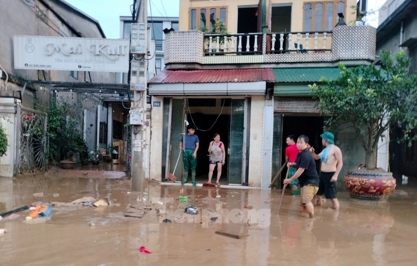 Người dân tranh thủ dọn dẹp bùn đất. Ảnh: Tiền Phong