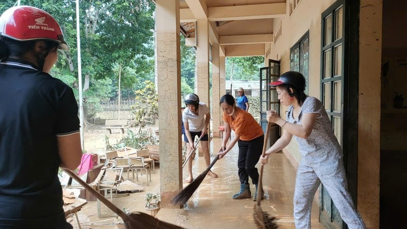 Thầy cô lội bùn dọn dẹp trường lớp để đón học sinh đi học trở lại. Ảnh: Tiền phong