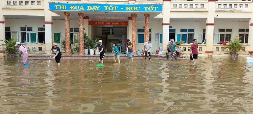 Các thầy cô giáo khùa bùn khu vực sân trường theo dòng nước rút
