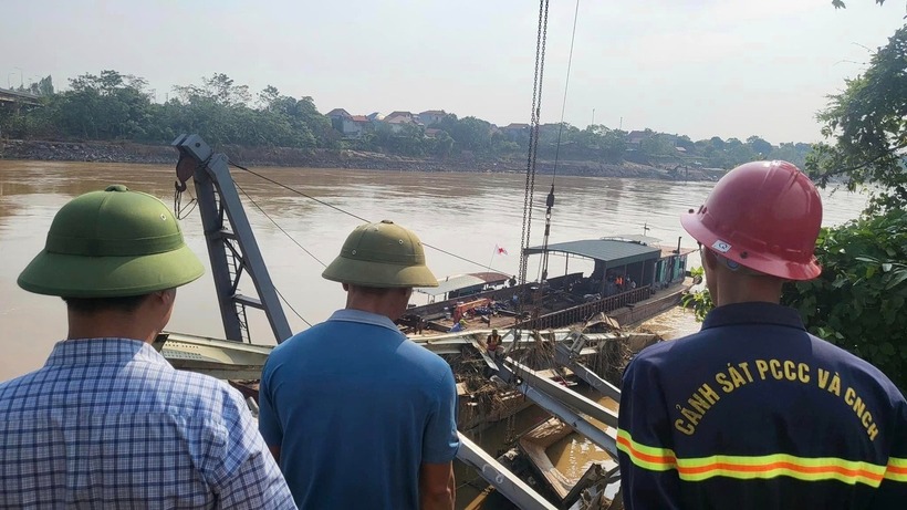 Lực lượng chức năng tỉnh Phú Thọ đang tiến hành trục vớt phương tiện và phần cầu Phong Châu bị chìm đắm. Ảnh: Dân Trí