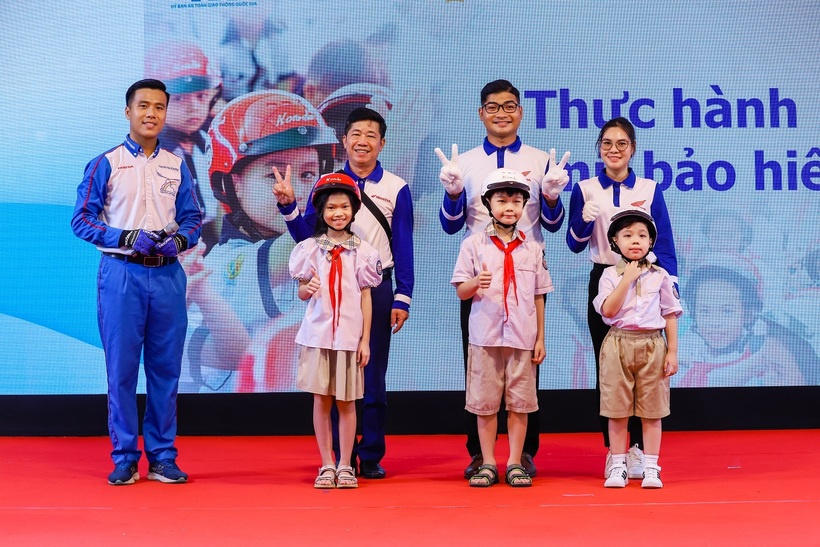 Các em học sinh thực hành đội mũ bảo hiểm đúng cách và an toàn