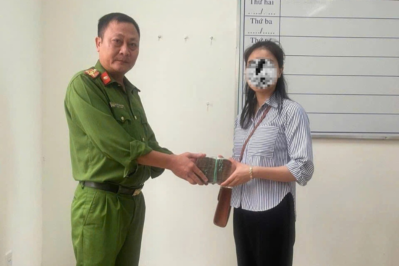 Chị L. xúc động khi nhận lại 320 triệu đồng từ cơ quan công an. Ảnh: Dân Trí
