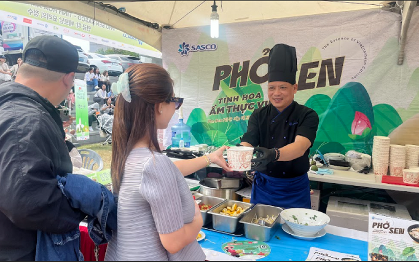 "Chúng tôi không chỉ nấu ăn, chúng tôi đang kể câu chuyện về văn hóa của mình," chia sẻ của một đầu bếp tại quầy Phở Sen. (Ông Nguyễn Văn Tấn – Bếp trưởng SASCO hối hả phục vụ thực khách những tô Phở Sen đặc sắc tại lễ hội )