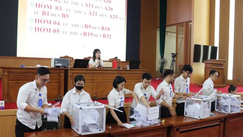 Ban tổ chức kiểm tra kết quả đấu giá. Ảnh: Hanoimoi